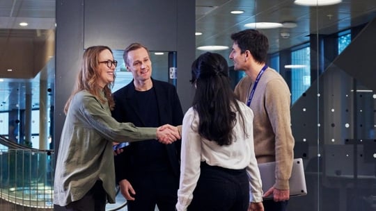 People meet and greet smiling shaking hands